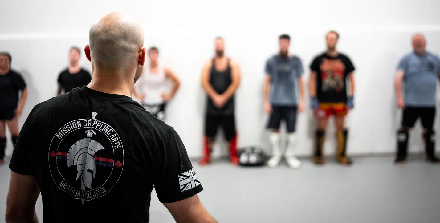 Head coach addressing a line of adult students before class at Mission BJJ in Mission, BC